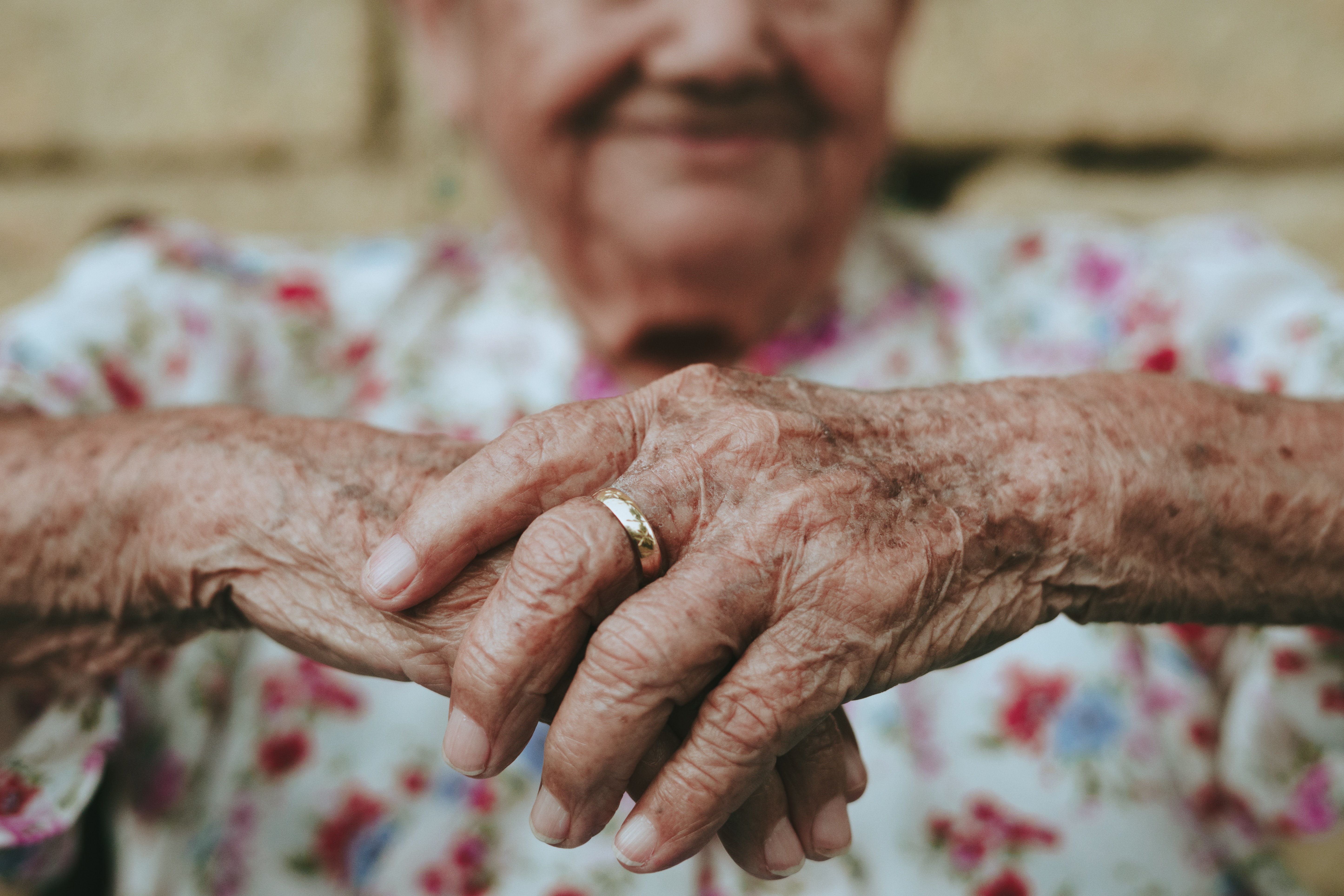Thantophobia's varied impact: Elderly woman's hands symbolize the fear of losing someone you love, with effects across age groups.